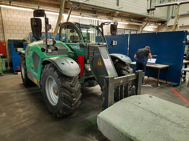 Prüfungssituation im Bereich «Facharbeiten ausführen Mechanische Antriebe» mit einem Kramer Teleskoplader.