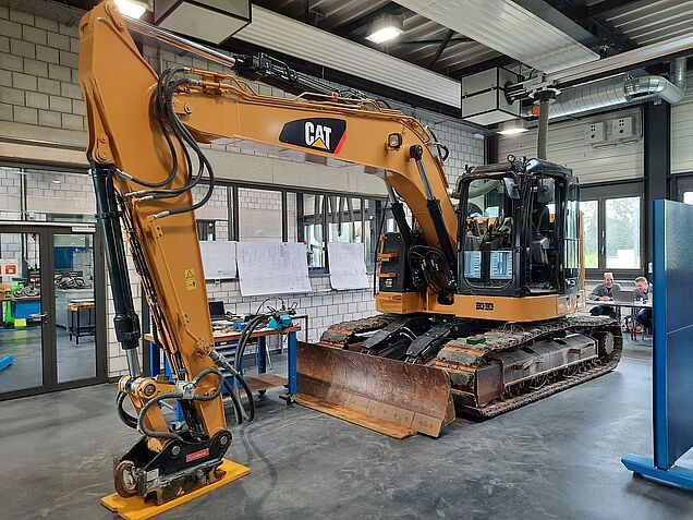 Situation d’examen dans le domaine « Effectuer des travaux spécialisés Machines de chantier » avec une pelleteuse de CAT.